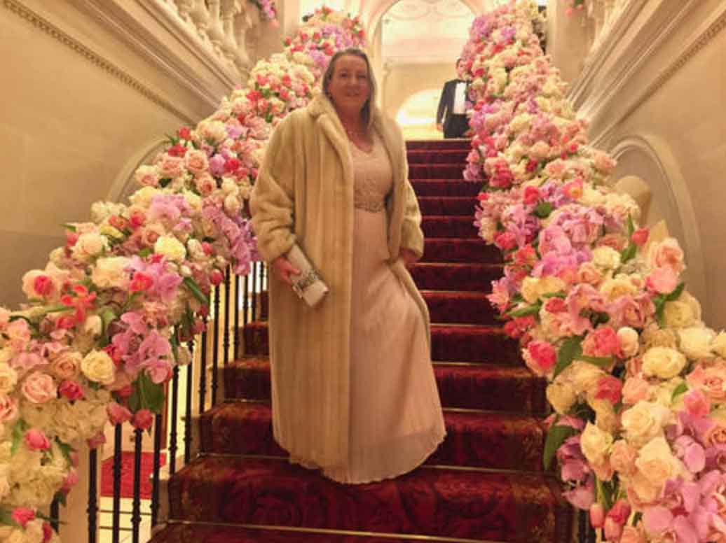 Jacqueline Joy Director of joys pictured on a staircase of flowers